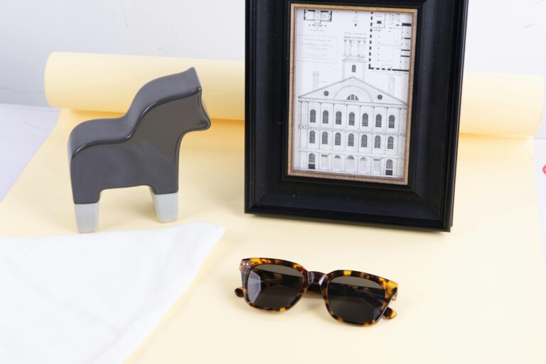 Stylish arrangement of home decor with sunglasses on a minimalist backdrop.